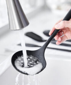 Black silicone kitchen utensils with stainless handles on countertop